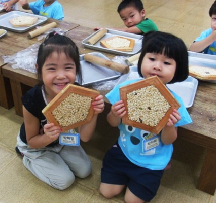 쌀잡곡강정을 들고 기념촬영을 하고있는 어린이들의 모습