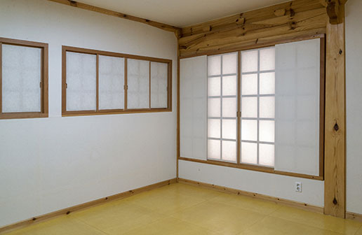 흰색 벽지 및 깔끔하게 리모델링된 방 내부 전경