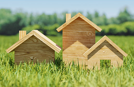 잔디밭 위에 나무로 된 집 모형 3개가 나란히 세워져 있는 모습