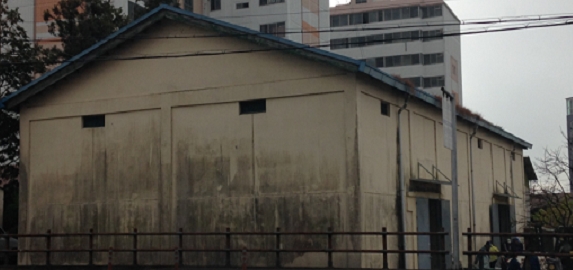 강진읍 서성리에 위치한 창고로 아파트 앞에 낡고 오래되어 벽면에 이끼가 끼어있는 창고가 보이는 전경입니다.