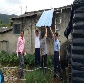 군동면, 사랑의 집수리 봉사 현장의 모습으로 선진건설관계자와 군동명장, 주민복지팀장, 팀원이 독거노인의 자택의 지붕을  교체 하고 있는 모습입니다.