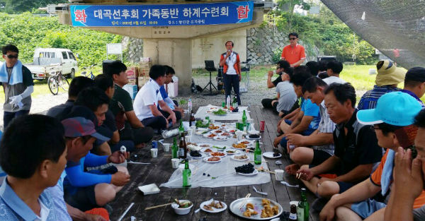 대곡선후회 하계수련회 사진으로 군동면 석교리 탐진강둔치 회원들이 둘러 앉아 식사를 하고 있는 모습입니다.
